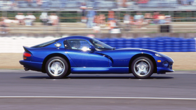 A side-profile of a 1990s blue Dodge Viper being driven on a track.