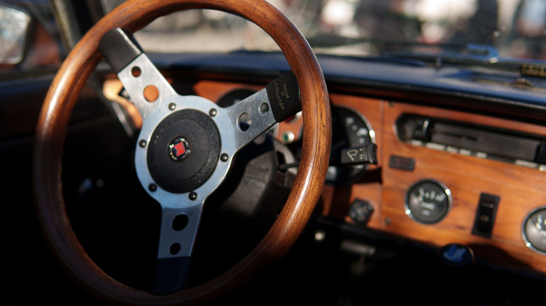 Vintage car dashboard with wooden steering wheel and wood-veneered dashboard