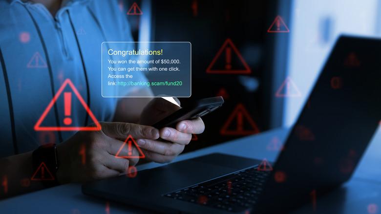 A person reading a fraud message on his phone,