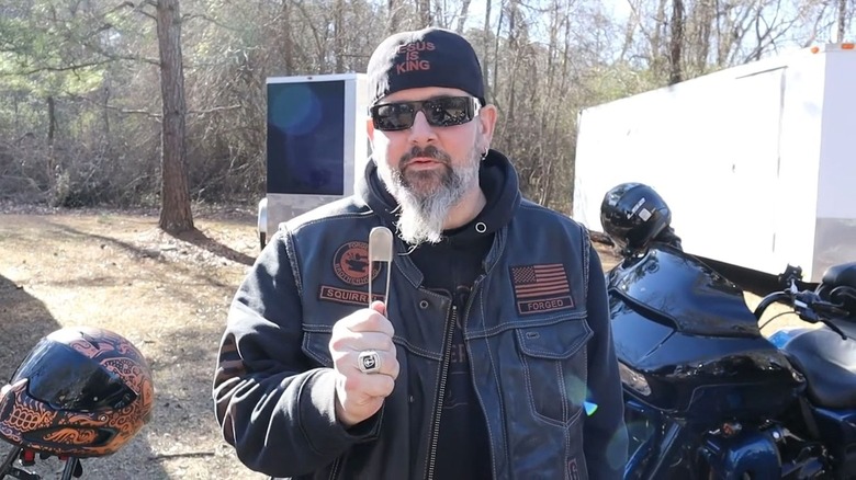 Biker holding a pass through pin up for the camera.