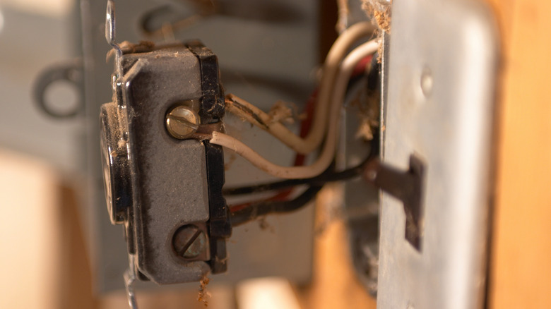An old 240V receptacle with black, white, and red wires attached to it.