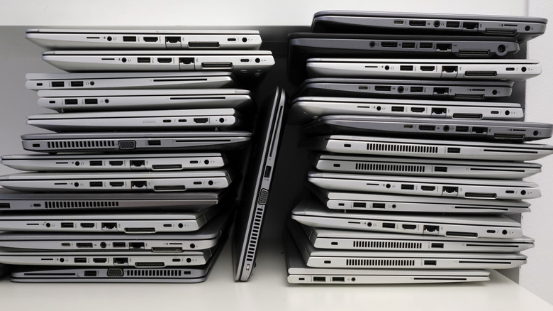 Stack of old laptops on a white shelf
