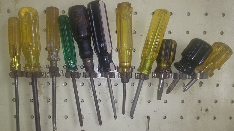 An array of CAB-handled screwdrivers on a wall rack.