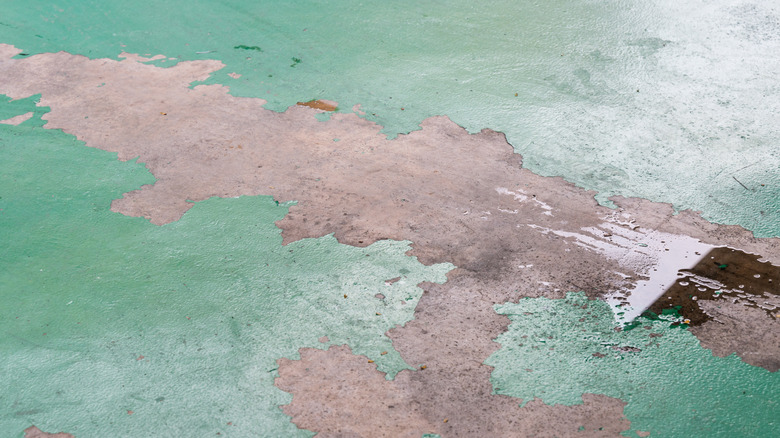An image of a garage floor with a peeling epoxy flooring
