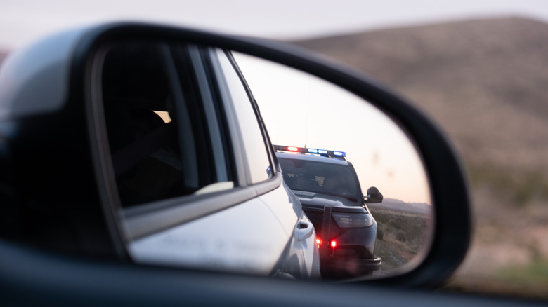 police pulling a man over, view from mirror