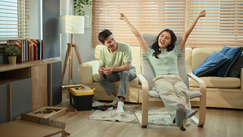 A man and woman celebrating after assembling furniture themselves