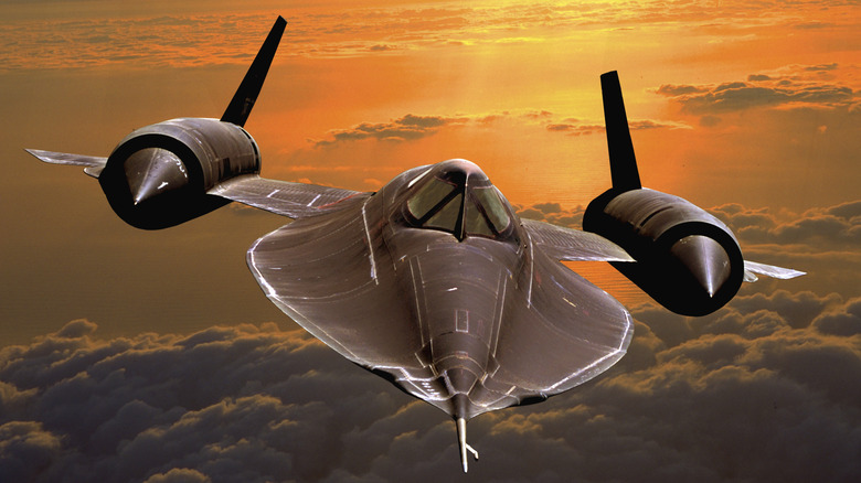 Close up of a 2 engine Air Force jet flying with a partly sunny sky in the background.