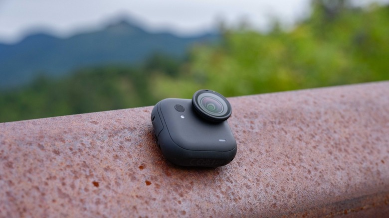 The standalone camera module of the Insta360 Go Ultra magnetically attached to a guard rail.