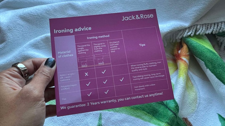 Author is holding the ironing advice card that came with the Jack & Rose travel steamer
