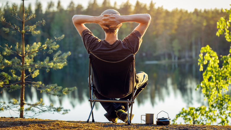 man relaxing by lake