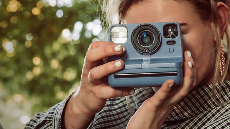 Woman using polaroid camera