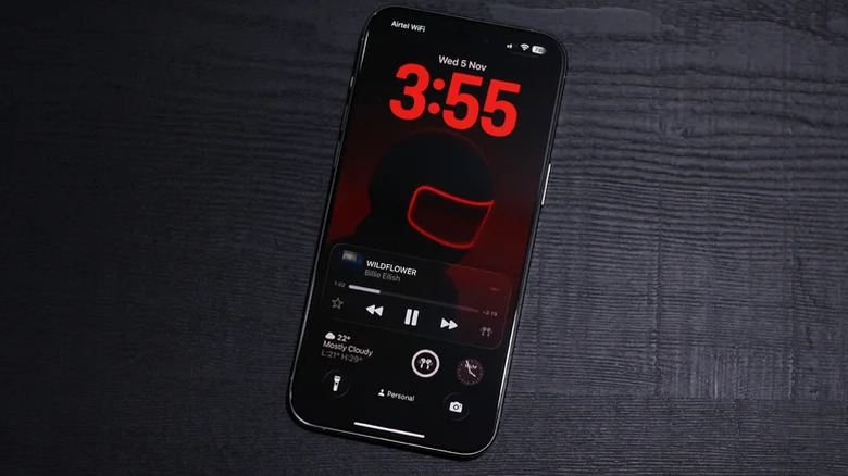 iOS 26 lock screen with a media player