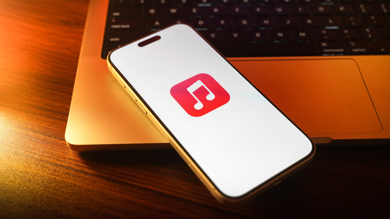 Apple music splash screen on a phone kept on a laptop