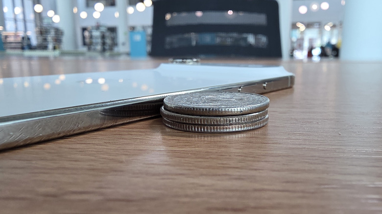 Quarters stacked next to an iPhone Air