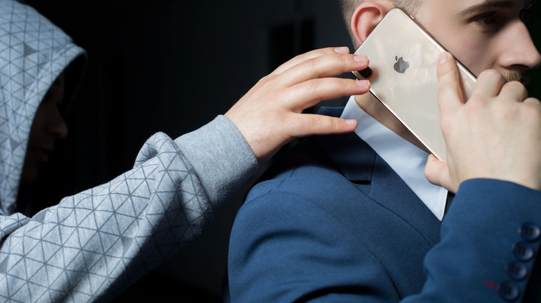 Masked thief snatching an iPhone XS
