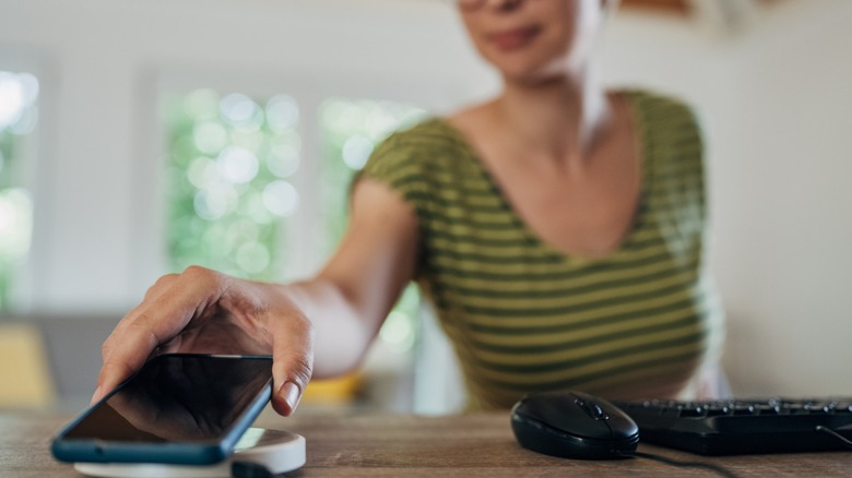 Woman using MagSafe charging case for iPhone