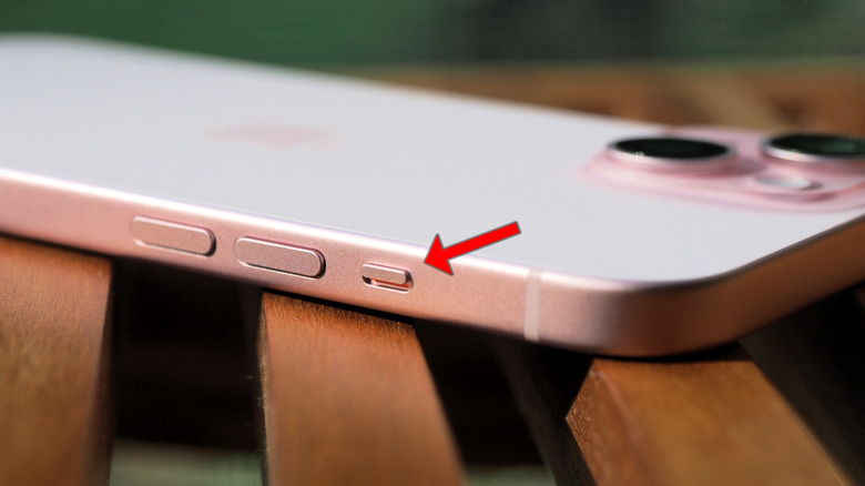 Image of the iPhone 15 in its Pink color, with an arrow highlighting the mute switch