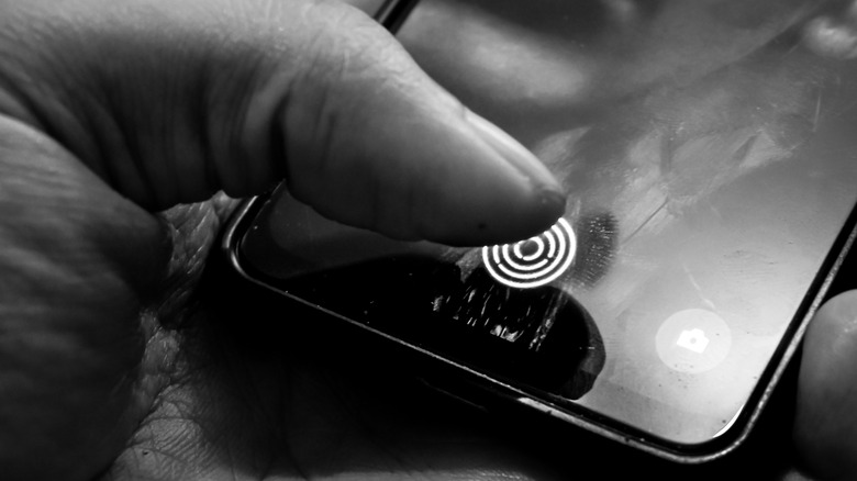 A person unlocking their phone using a fingerprint scanner