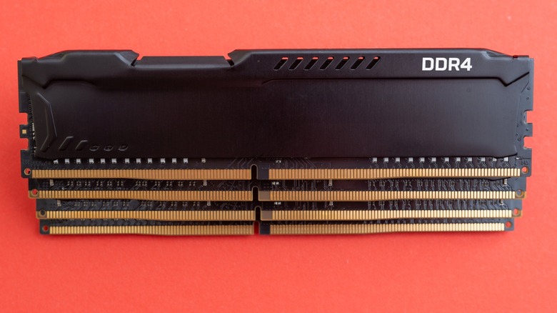 Four DDR4 modules stacked on each other against an orange background