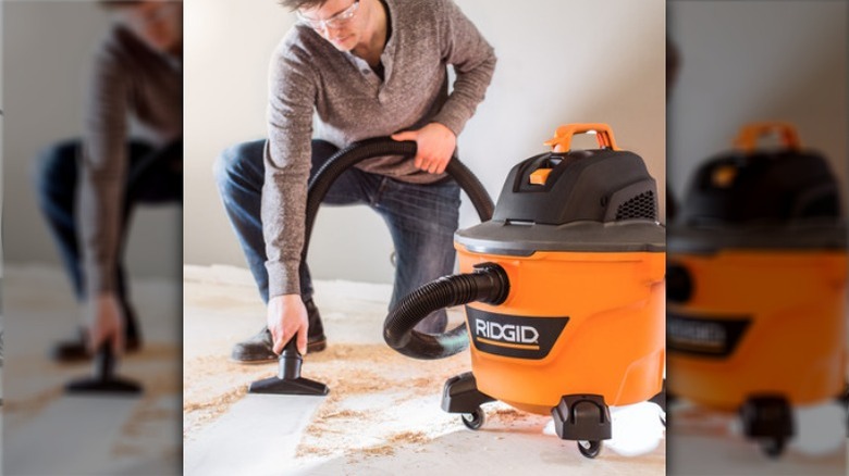 Person cleaning floor with Ridgid shop vac