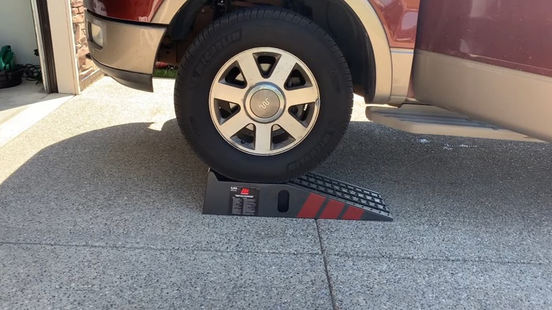 A red car parked on a set of automotive ramps