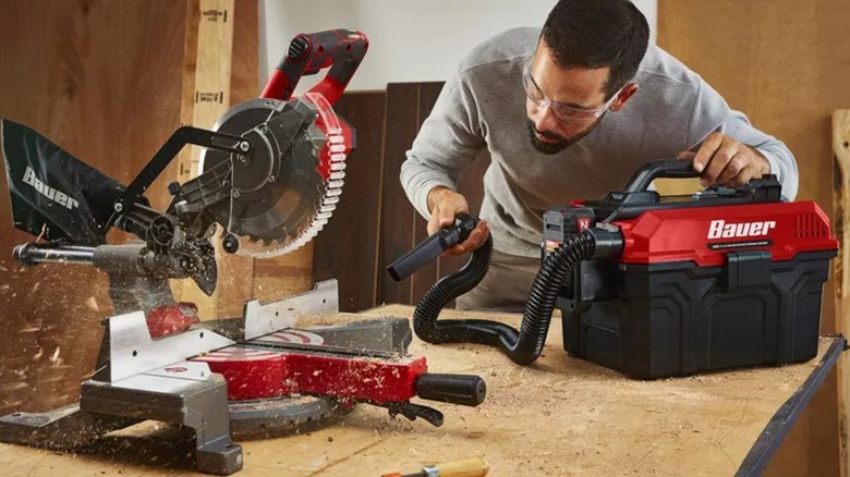 man using small Bauer wet and dry vacuum