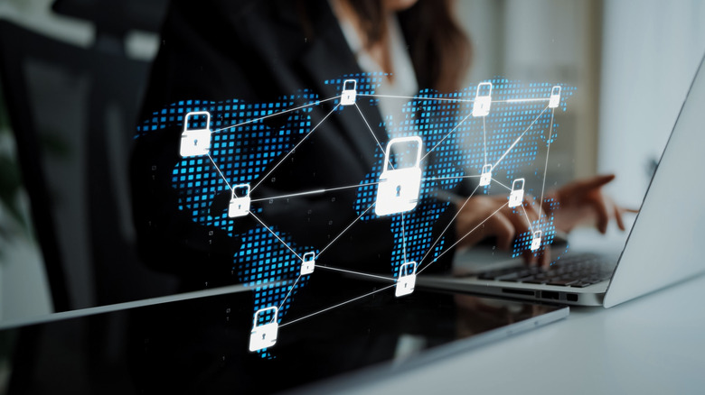 Someone using a laptop with a network map of padlocks above it.