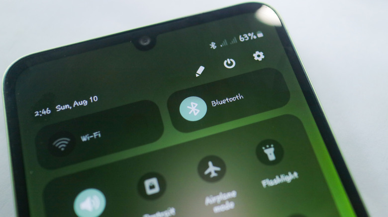 Close-up of smartphone screen showing Bluetooth icon in On position and other connectivity icons in quick menu.