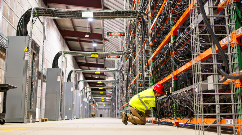 Worker inspecting hardware in a massive data center