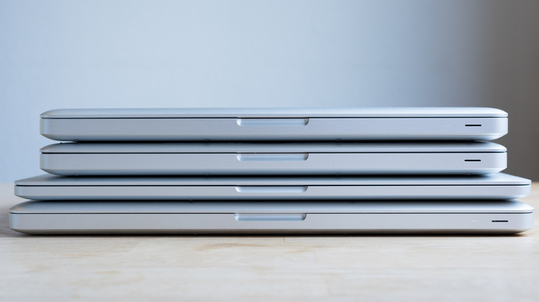 Four MacBooks stacked atop one another