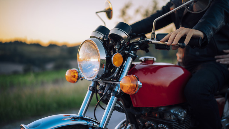 A person sitting on a motorcycle outside.