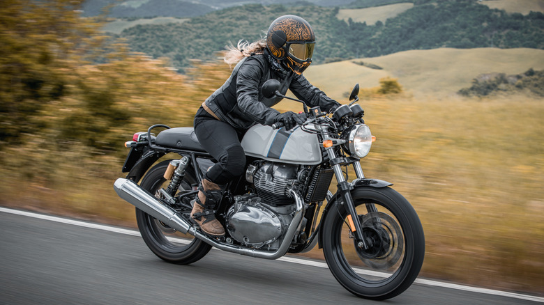A person riding an old motorcycle.