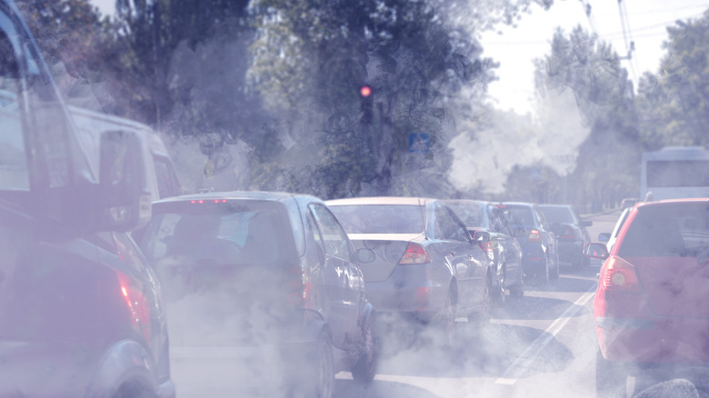 Lines of traffic surrounded by exhaust smoke and haze