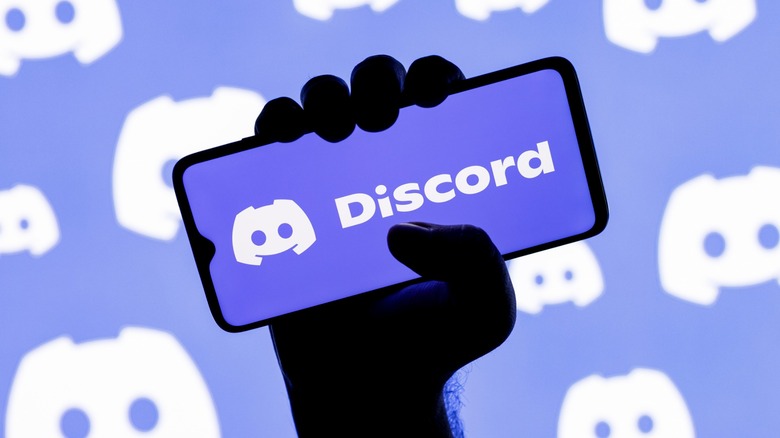 man holding phone with Discord app