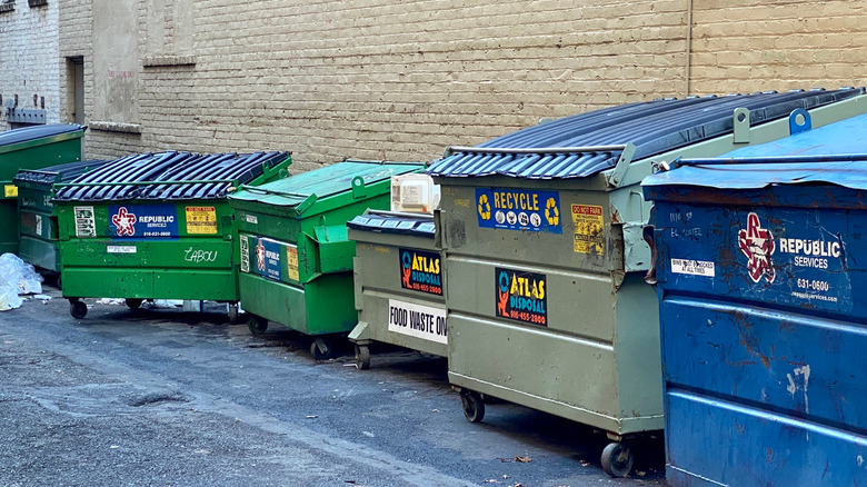 A line of dumpsters in an alley.
