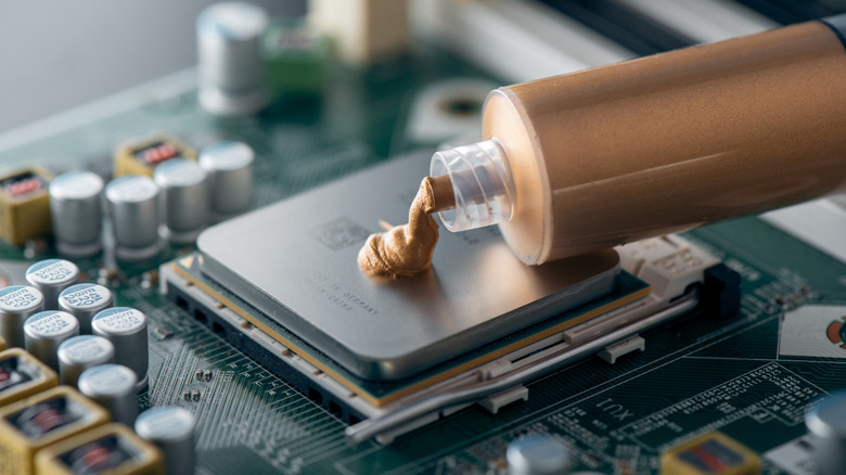 PC builder applying thermal paste on an AMD Ryzen CPU
