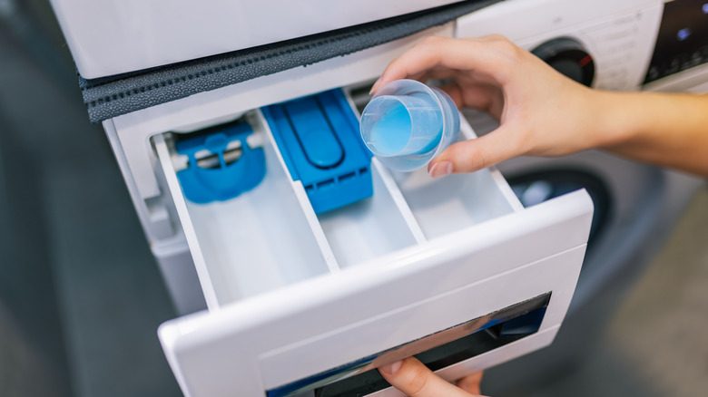 Woman puts softener in the washing machine