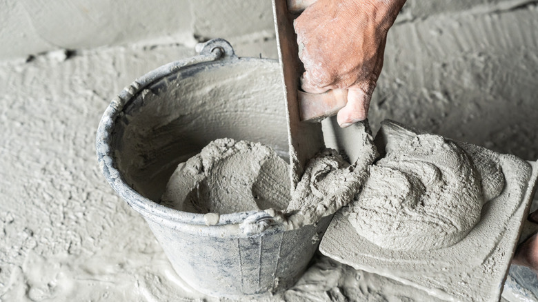 Person using a trowel to spread concrete