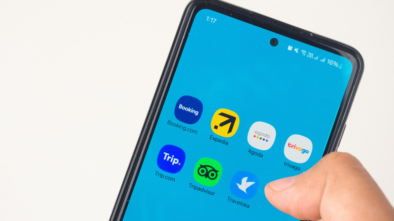person selecting from smartphone travel apps with thumb