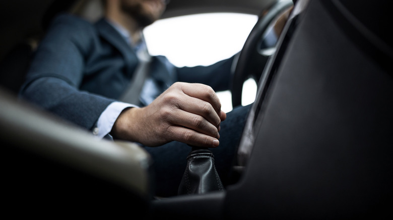 Businessman driving his car ,focus on a gear stick