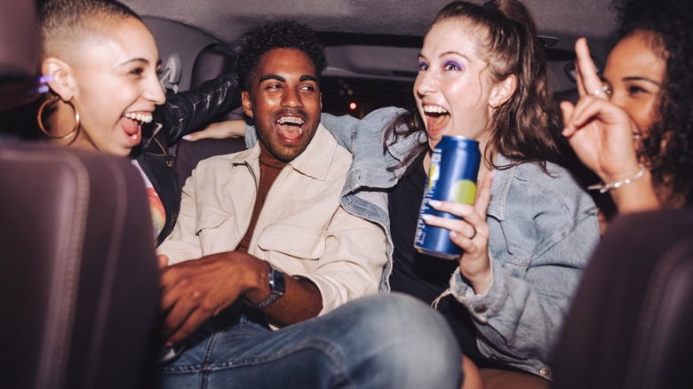 Four people having a good time in the back of a vehicle