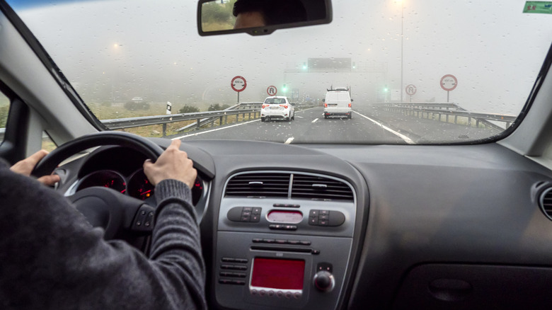 A person behind the wheel driving during bad weather