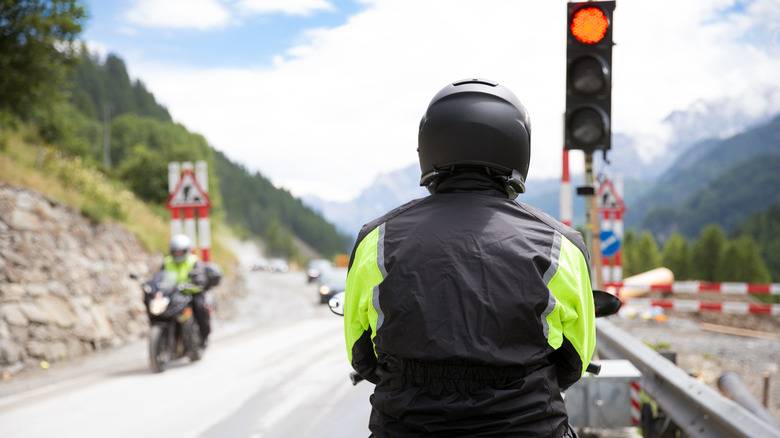 A biker on a motorcycle waits at a red light