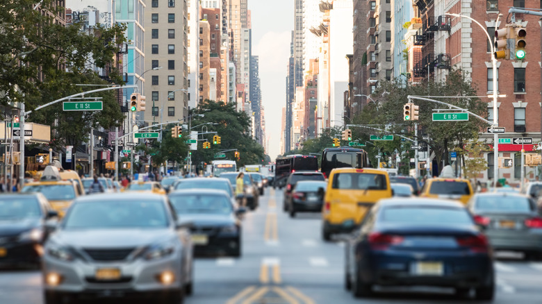 New York City busy street scene with cars and people along 3rd Avenue in the East Village of Manhattan