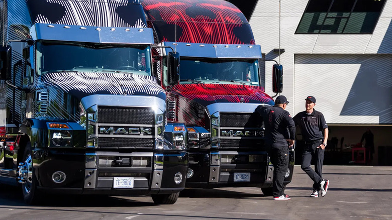 Two Mack Trucks parked with drivers talking