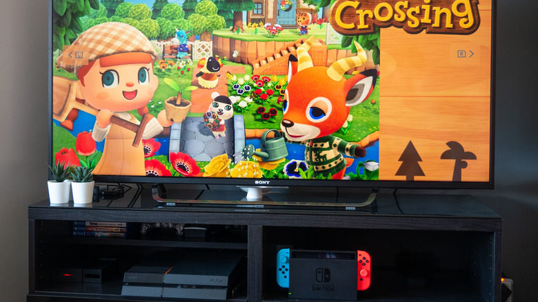 Nintendo Switch docked in entertainment center, with "Animal Crossing" playing on the TV