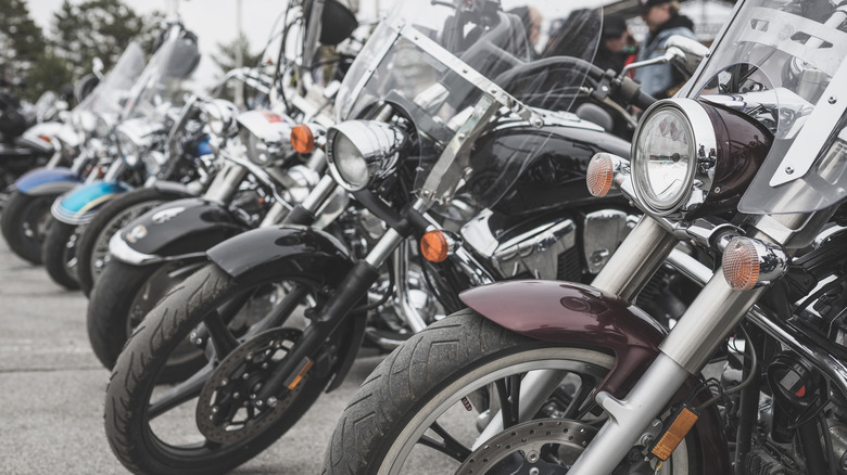 Several old motorcycles standing alongside each other