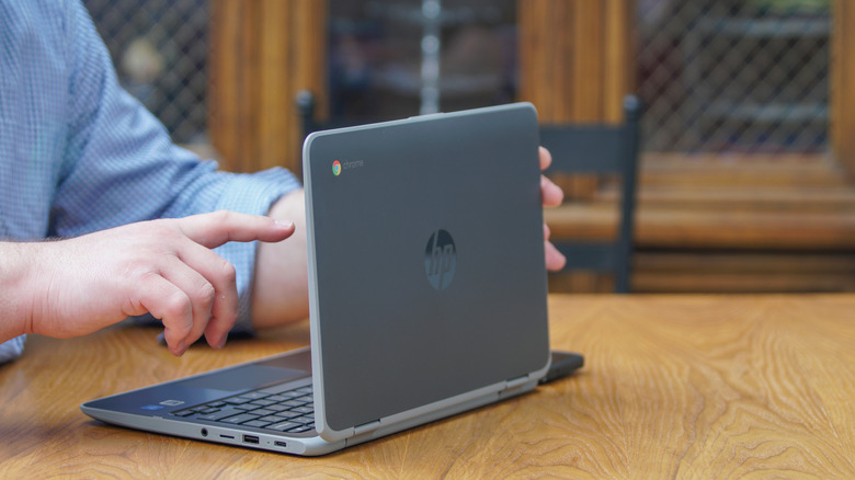 Person preparing to touch a Chromebook's screen
