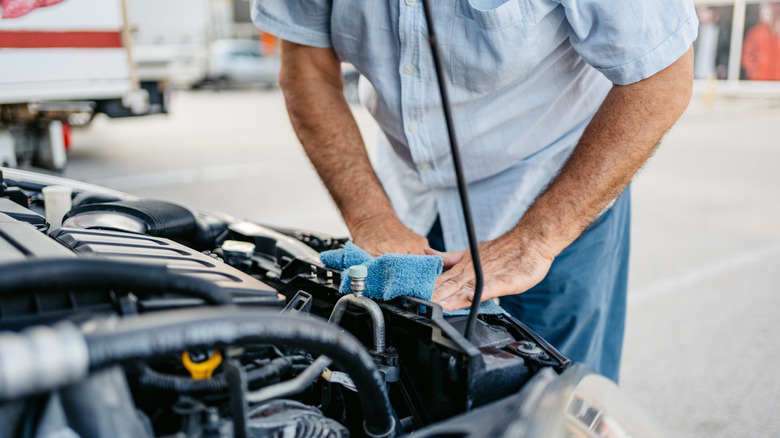 Old gentleman wiping the engine bay with a rag