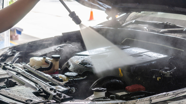 Hosing down the engine bay with a pressure washer
